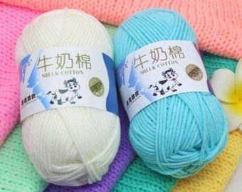 May include: Two skeins of yarn, one white and one light blue, with the text "牛奶棉" (Milk Cotton) and "牛奶奶" (Milk Cotton) on the labels.