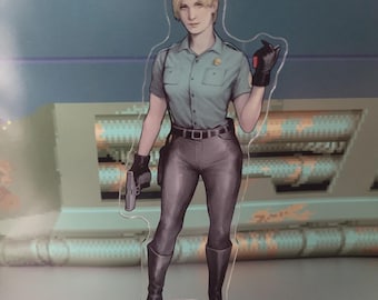 May include: A clear acrylic figure of a woman in a teal short-sleeved uniform shirt, gray pants, and black boots. She holds a gun in one hand and wears black gloves. The figure has blonde hair and a serious expression.