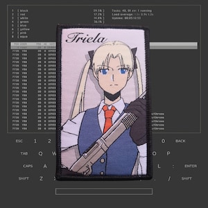 May include: An embroidered patch featuring an anime character named "Triela" holding a rifle. The character has blonde hair, blue eyes, and is wearing a blue waistcoat, white shirt, and red tie.