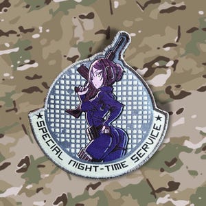 Op de afbeelding: Een wit en grijs geborduurde patch met een cartoon anime vrouw die een geweer vasthoudt. De patch heeft de tekst "Special Night-Time Service" rond de rand.