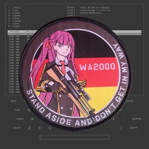 May include: A black and white embroidered patch with a cartoon woman holding a rifle. The patch has the text "WA2000" and "STAND ASIDE AND DON'T GET IN MY WAY" around the edge.
