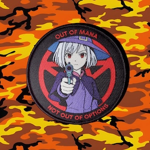 May include: Round patch featuring an anime-style character with white hair, a purple hat, and a purple outfit, holding a gun. The patch has the text "OUT OF MANA" and "NOT OUT OF OPTIONS" in white. The background is orange and yellow camouflage.