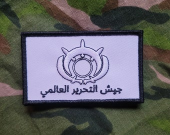 May include: White patch with black border, featuring a white emblem with a circle and crescent moon design. The text "جيش التحرير العراقي" is written in Arabic below the emblem.