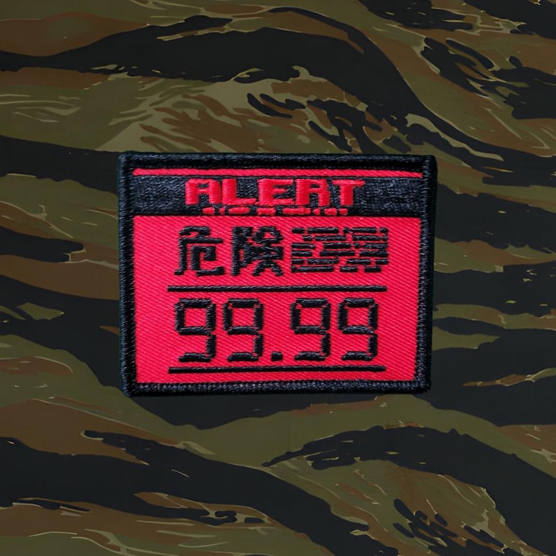 May include: A red and black embroidered patch with the text "ALERT" in black and "危险警報" in red, followed by the number "99.99" in red.