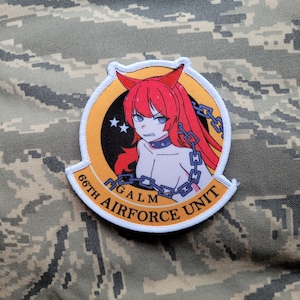 May include: A white, yellow, and blue embroidered patch with a cartoon image of a red-haired woman with horns and a chain around her neck. The text "66TH AIRFORCE UNIT" is written around the edge of the patch.