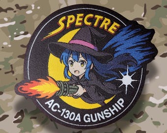 May include: A circular patch featuring an anime-style witch with blue hair, wearing a black hat with a pink band, and holding a gun that is firing flames. The patch has the text "SPECTRE" and "AC-130A GUNSHIP".