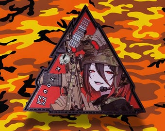 May include: A triangular patch featuring an anime-style character in a military helmet, holding a rifle. The patch has red and black accents with the text "F YOU" and a symbol. The background is orange and yellow camouflage.