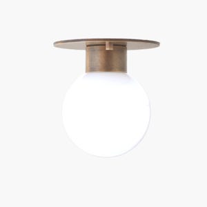 May include: A modern ceiling light fixture featuring a round, frosted white glass globe. The light is supported by a cylindrical brass-toned base and a circular, flat brass-toned canopy. The design is minimalist and suitable for various interior styles.