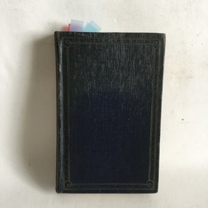 May include: A dark blue hardcover book with a gold decorative border around the cover. The book has a textured surface and is slightly worn.