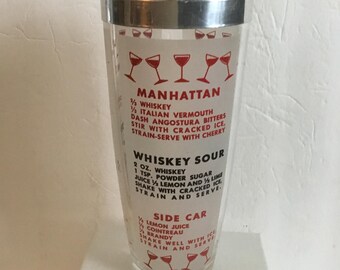 Coctelera vintage de vidrio de los años 50 con gráficos de recetas de cócteles en rojo, blanco y negro y tapa de aluminio