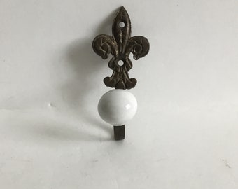 Metal Bronze Colored  Fleur De Lis Wall Hook With White Ceramic Finial  L 3.25” W 1 3/8”