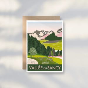 May include: A greeting card with a landscape illustration of the Vallée du Sancy in France. The artwork features green trees, rolling hills, and snow-capped mountains under a pink and blue sky. The text "Let's Walk" and "Vallée du Sancy" are displayed.