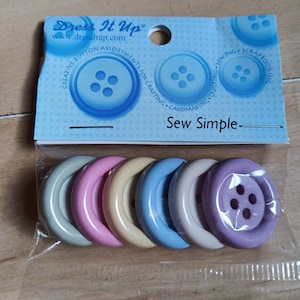 May include: A package of six sew-on buttons in various pastel colors. The buttons are round and have four holes. The package is labeled "Dress It Up" and "Sew Simple".
