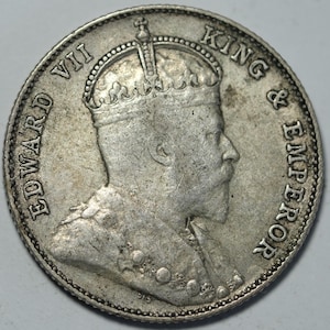May include: Silver coin depicting a profile portrait of King Edward VII, with the inscription "EDWARD VII KING & EMPEROR" around the edge.