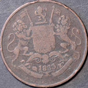 May include: A copper coin featuring two lions flanking a shield with flags. The coin has the year 1833 inscribed on a banner below the shield. The coin's design is detailed and shows signs of wear.