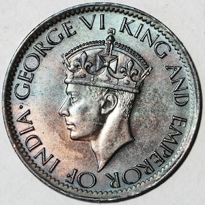 Może przedstawiać: Srebrna moneta z profilem króla Jerzego VI, w koronie, z napisem "INDIA GEORGE VI KING AND EMPEROR OF" wokół krawędzi.
