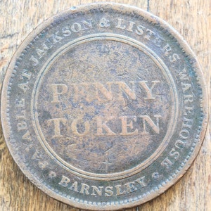 Può includere: Un gettone di rame da un penny della società "Able & Jackson & Listers Warehouse Barnsley". Il gettone presenta le parole "Penny Token" al centro.
