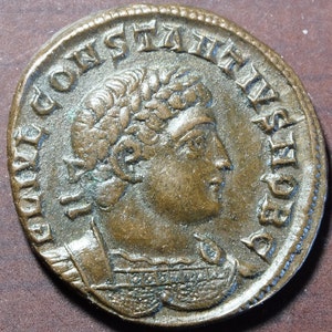 Op de afbeelding: Een bronzen munt met een portret van een man met een lauwerkrans op zijn hoofd. De inscriptie rond het portret luidt "DN CONSTANTINVS AVG".