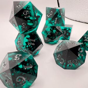 May include: A set of three ceramic mugs with a speckled, matte finish. The mugs are in shades of cream, light brown, and dark brown. Each mug has a simple, minimalist design and a rounded handle.