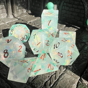 May include: A set of iridescent, light blue polyhedral dice with red numbering. The dice are in various shapes, including D4, D6, D8, D10, D12, D20, and a cube. The dice are designed for tabletop role-playing games.