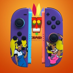 K&ouml;nnte beinhalten: Lila und orangefarbene Nintendo Switch Joy-Con-Controller mit Crash Bandicoot-Charakteren. Die Controller haben Charakterillustrationen und das Logo des Spiels. Der Hintergrund ist ein Orangegradient.