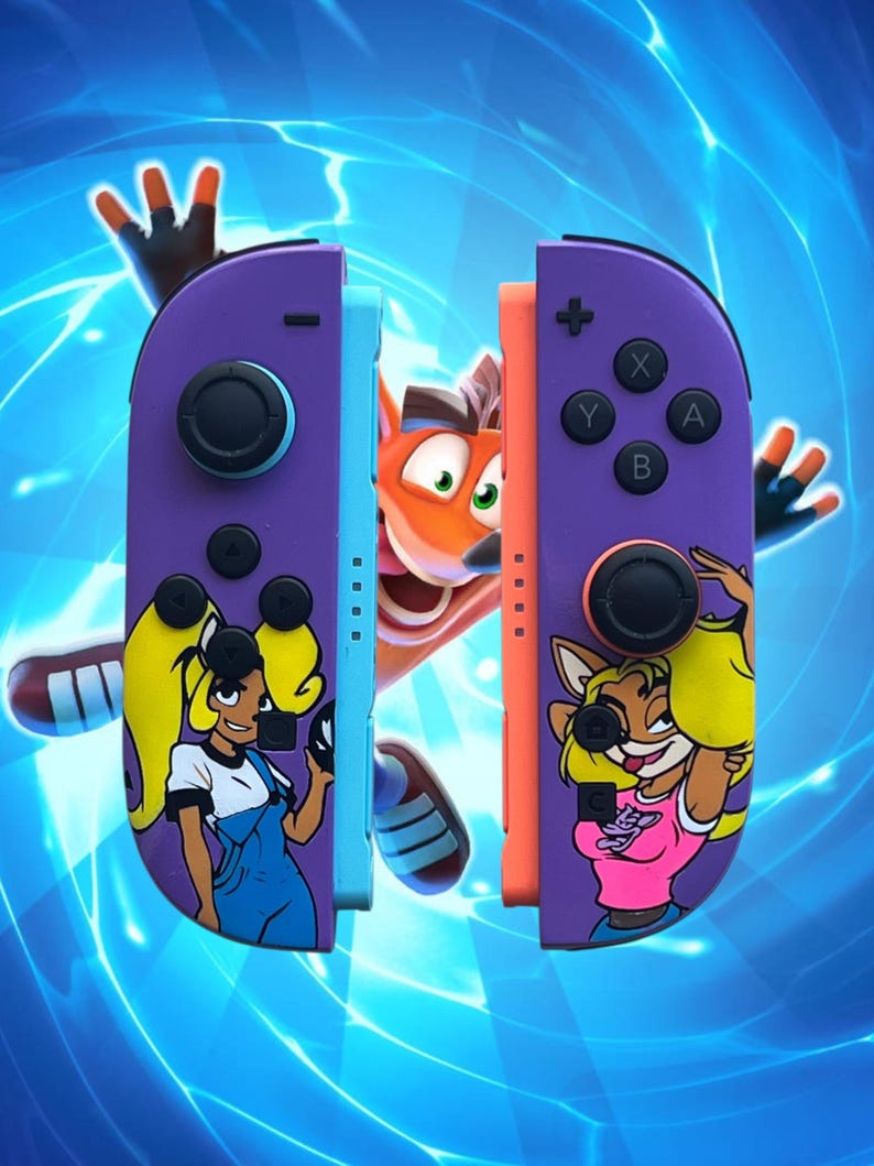K&ouml;nnte beinhalten: Lila und orangefarbene Gamecontroller-Griffe mit Cartoon-Charakter-Designs. Die Griffe zeigen Bilder von Crash Bandicoot-Charakteren. Der Hintergrund ist ein blaues, elektrisch thematisiertes Design.