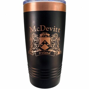 May include: Black insulated tumbler with a copper-colored rim and lid. The tumbler features the name "McDevitt" and a family crest with the word "Ireland" below it, all in a copper color.