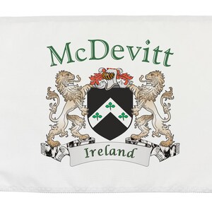 May include: White flag with the name "McDevitt" in green script above a coat of arms. The coat of arms features a black shield with three green shamrocks, flanked by two tan lions. The word "Ireland" is printed on a banner.