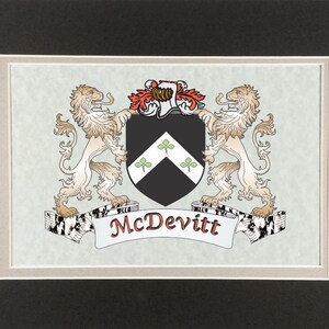May include: A framed heraldic crest featuring a black shield with three green shamrocks, flanked by two tan lions. The name "McDevitt" is displayed on a banner below the shield, with a light blue background.