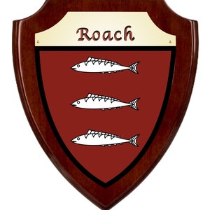 May include: A wooden shield-shaped plaque with a dark brown border and a burgundy center. The plaque features three white fish and the name "Roach" in gold lettering.