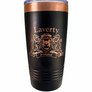 May include: Black insulated tumbler with a copper-colored rim and lid. The tumbler features the name "Laverty" above a coat of arms with the word "Ireland" on a banner. The design is in a copper color.