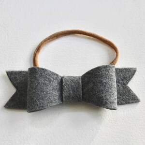 May include: A gray felt bow headband with a brown elastic band.