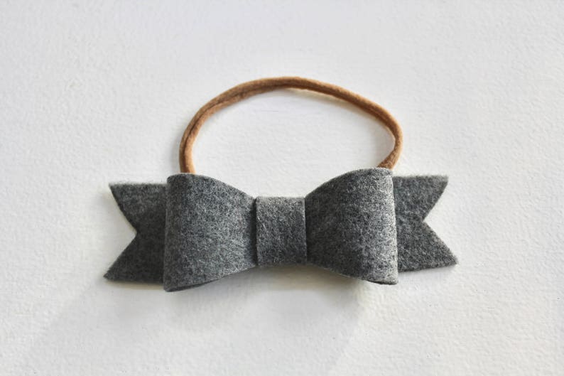 May include: A gray felt bow headband with a brown elastic band.