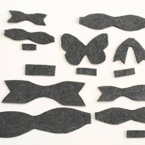 May include: A set of felt shapes in gray, including butterflies, bows, and rectangles. These shapes can be used for crafting projects.