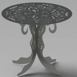 May include: A black metal side table with a round, intricately patterned top and a unique, four-legged base.