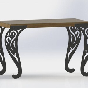 May include: A wooden table with a black metal base. The base features intricate, decorative cutouts in a swirling pattern.