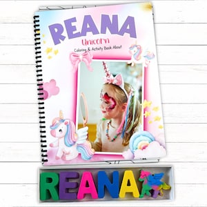 May include: A spiral-bound coloring and activity book titled REANA Unicorn Coloring & Activity Book About featuring a photo of a child with face paint and a unicorn headband, accompanied by a box of colorful letter-shaped crayons spelling REANA.