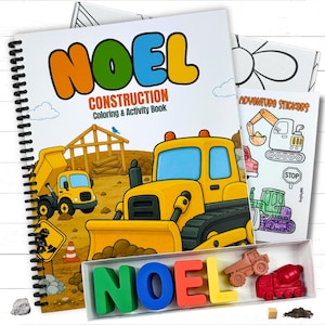 A personalized children's construction activity coloring book with the name Noel on the cover, a matching set of custom name letter wax crayons, a vehicle sticker sheet, and an illustrated gift box on a white wood tabletop.