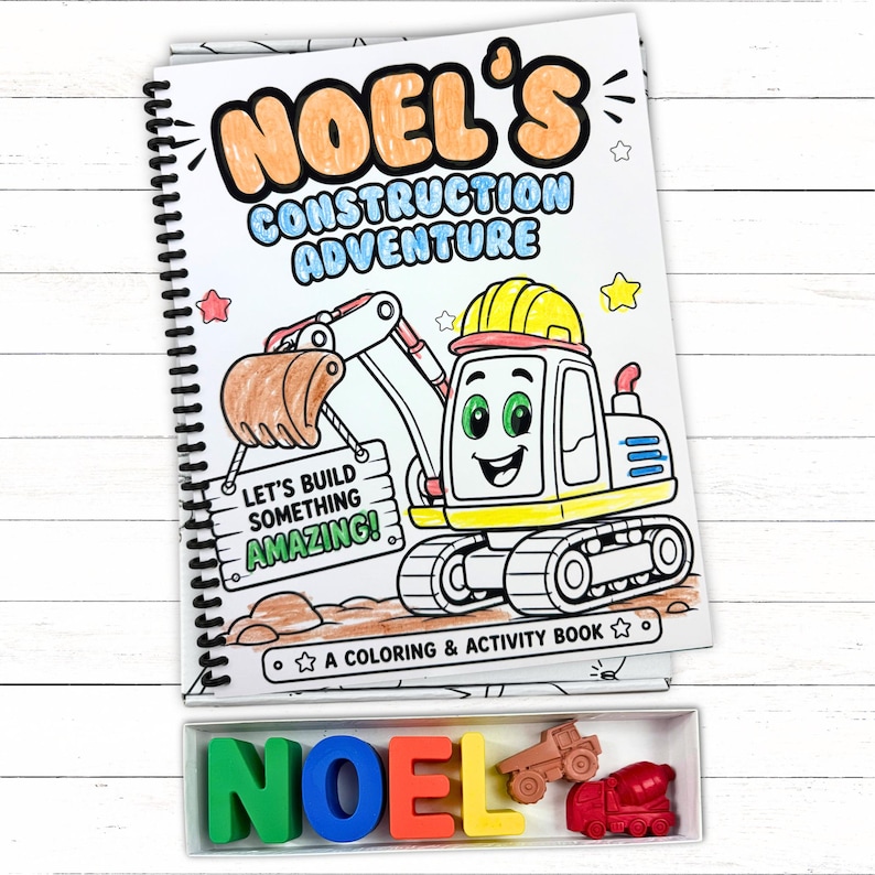 A custom black and white construction coloring book displayed right above a window box of matching hand poured wax name crayons spelling NOEL on white wood.