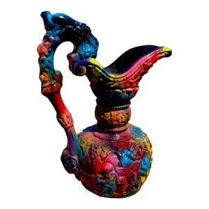 May include: A vibrantly painted decorative pitcher with a curved handle and spout. The pitcher is adorned with intricate carvings and painted in a rainbow of colors, including red, blue, yellow, and green. The handle features a bird-like sculpture.