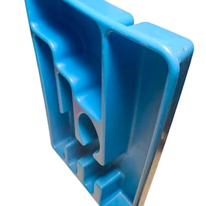 May include: A bright blue plastic organizer with multiple compartments and a curved handle. The organizer has a rectangular shape with various slots and a circular opening. The design is simple and functional.
