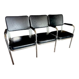 May include: A set of three black leather chairs with chrome frames. The chairs are connected together to form a bench.