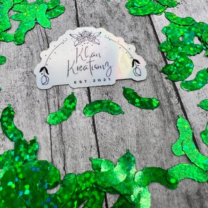 May include: Green glitter sticker with the text "Khan Kreations EST. 2021" surrounded by green glitter confetti.