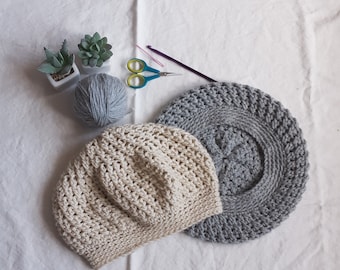 May include: Two crocheted hats, one in beige and one in gray, with a ball of gray yarn and crochet hooks.