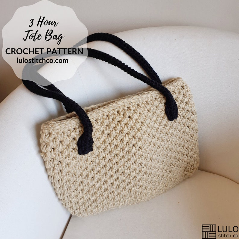 May include: A beige crocheted tote bag with black handles. The bag is sitting on a white surface. The text "3 Hour Tote Bag CROCHET PATTERN lulostitchco.com" is visible in the image.