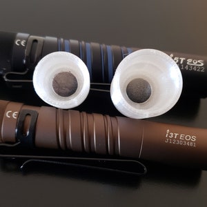 May include: Two flashlights with a black and brown finish, each with a white diffuser and the text "i3T EOS" and a serial number.