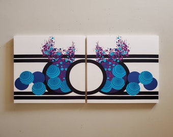May include: Two white canvases with black stripes and a large circle in the center. The circles are filled with a pattern of blue and purple circles. The circles are surrounded by a cluster of smaller blue and purple circles.