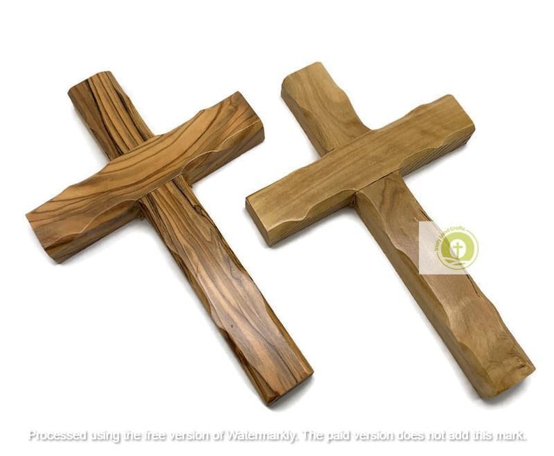 May include: Two wooden crosses with a natural wood grain pattern. The crosses are made of light brown wood and have a simple, traditional design. The crosses are likely used for religious purposes.