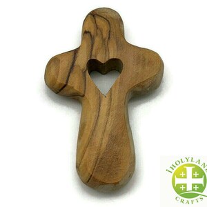 May include: A wooden cross with a heart-shaped cutout in the center. The cross is made of olive wood and has a natural brown color.