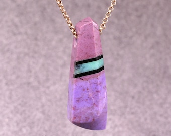 May include: A purple and green stone pendant with a gold chain. The stone is a long, pointed shape with a black and green inlay.